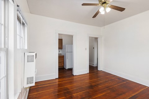 a bedroom with hardwood floors and white walls